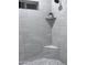 Modern shower featuring light gray marble-look tiles, built-in shelving, and a corner seat, enhancing the bathroom's luxurious appeal at 22205 W Ocupado Dr, Wittmann, AZ 85361