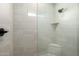 Modern shower stall showcasing tiled walls, built-in niche and seating at 22205 W Ocupado Dr, Wittmann, AZ 85361