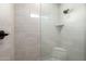 Tiled shower stall featuring tiled walls, built-in niche and corner seating at 22205 W Ocupado Dr, Wittmann, AZ 85361