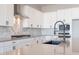 Modern kitchen featuring white cabinets, quartz countertops, and black appliances at 20252 W Catalina Dr, Buckeye, AZ 85396