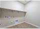 Laundry room with overhead shelving and tile flooring at 20252 W Catalina Dr, Buckeye, AZ 85396