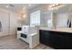 Large bathroom with double vanities, a soaking tub, and dark cabinetry at 130 N Bay Dr, Gilbert, AZ 85233