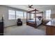 Spacious bedroom with a four-poster bed, carpeted floor, and large windows at 130 N Bay Dr, Gilbert, AZ 85233