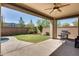 Covered patio with grill, table, and ceiling fan at 130 N Bay Dr, Gilbert, AZ 85233