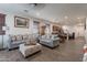 Bright living room features two comfy sofas, an ottoman, and wood-look floors at 21667 S 225Th Way, Queen Creek, AZ 85142