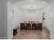 Dining room with long table, seating for eight and modern lighting viewed through an arched hallway at 12651 S 71St St, Tempe, AZ 85287