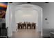 Dining room with long table, seating for eight and modern lighting viewed through an arched hallway at 12651 S 71St St, Tempe, AZ 85287