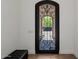 Elegant foyer with a decorative wrought iron front door and black leather bench at 12651 S 71St St, Tempe, AZ 85287