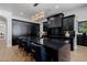Stunning kitchen with black cabinets, gold hardware, marble countertops and modern lighting fixture over the island at 12651 S 71St St, Tempe, AZ 85287