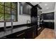 Chic kitchen featuring black cabinets, stone countertops, and modern fixtures at 12651 S 71St St, Tempe, AZ 85287