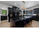 Stunning kitchen with black cabinets, gold hardware, marble countertops and modern lighting fixture over the island at 12651 S 71St St, Tempe, AZ 85287