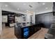 Gourmet kitchen island with seating, a wine fridge, black countertops and open living space at 12651 S 71St St, Tempe, AZ 85287