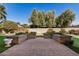 Landscaped backyard with stone planters and putting green at 25809 S Hollygreen Dr, Sun Lakes, AZ 85248