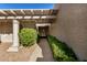 Inviting entryway with a pergola, lush landscaping, and decorative gate at 25809 S Hollygreen Dr, Sun Lakes, AZ 85248