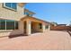 Home's backyard featuring red brick pavers, a covered patio, and a block wall at 19591 W Lincoln St, Buckeye, AZ 85326