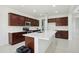 Bright kitchen with stainless steel appliances, white countertops, and dark wood cabinets at 19591 W Lincoln St, Buckeye, AZ 85326