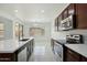 Modern kitchen with stainless steel appliances, white countertops, and dark wood cabinets at 19591 W Lincoln St, Buckeye, AZ 85326