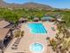 View of the community pool area including lap lanes, lounge chairs, hot tub and desert landscaping at 3518 N Shadow Trl, Mesa, AZ 85207