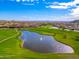 Aerial view of the golf course surrounded by lush green landscaping and beautiful mountain views at 3518 N Shadow Trl, Mesa, AZ 85207