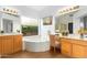 Bright bathroom boasts dual vanities, soaking tub, and serene natural light at 902 E Goldenrod St, Phoenix, AZ 85048