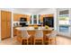 Eat-in kitchen with center island, natural wood cabinets, and black appliances at 902 E Goldenrod St, Phoenix, AZ 85048