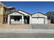 New home exterior with gray siding, brick accents, and a 2-car garage at 1184 E Gleneagle Dr, Chandler, AZ 85249