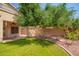 Backyard featuring a lush green lawn, shade trees, and a covered patio, offering a serene outdoor retreat at 15115 W Cottonwood St, Surprise, AZ 85374