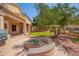 Well-maintained backyard with a barbecue, fire pit, manicured lawn, and landscaped features, ideal for outdoor living at 15115 W Cottonwood St, Surprise, AZ 85374
