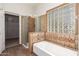 Primary bath with tiled shower, soaking tub, and tiled accent wall at 15115 W Cottonwood St, Surprise, AZ 85374