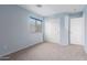 Light blue bedroom features carpeted floors, bright windows, and white closet doors at 15115 W Cottonwood St, Surprise, AZ 85374
