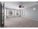 Spacious carpeted bedroom with ceiling fan and multiple windows providing ample natural light at 15115 W Cottonwood St, Surprise, AZ 85374