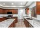Modern kitchen featuring stainless steel appliances, granite counters, and dark wood cabinetry at 15115 W Cottonwood St, Surprise, AZ 85374