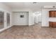 Spacious living area with tiled floors, open floor plan, French doors, and access to the kitchen at 15115 W Cottonwood St, Surprise, AZ 85374