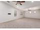Spacious living room with neutral carpet, multiple windows, and ceiling fans at 15115 W Cottonwood St, Surprise, AZ 85374