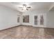 Bright living room featuring tile floors, a ceiling fan, and access to the patio through double doors at 15115 W Cottonwood St, Surprise, AZ 85374