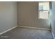 Cozy bedroom featuring soft gray carpet and a bright window at 10015 W Verde Ln, Avondale, AZ 85392