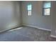 Well-lit bedroom with gray carpet and two windows at 10015 W Verde Ln, Avondale, AZ 85392