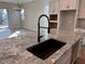 Kitchen island with sleek black faucet, granite counters, and natural light at 10015 W Verde Ln, Avondale, AZ 85392