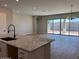 Open kitchen with granite counters, island with sink, and sliding glass doors leading outdoors at 10015 W Verde Ln, Avondale, AZ 85392