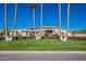 Stunning home showcasing desert landscaping with manicured lawn and tall palm trees against a clear blue sky at 10512 E Cortez Dr, Scottsdale, AZ 85259