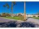 Elegant home with desert landscaping, tall palms, and a circular driveway, blending sophistication with natural beauty at 10512 E Cortez Dr, Scottsdale, AZ 85259