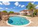 Inviting kidney-shaped pool with rock feature in backyard at 11543 E Quade Ave, Mesa, AZ 85212