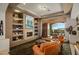 Cozy living room with a fireplace, built-in shelving, and access to an outdoor patio at 10911 E Taos Dr, Scottsdale, AZ 85262