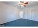 Well-lit bedroom featuring a ceiling fan and double doors to closet at 19661 N Echo Rim Dr, Surprise, AZ 85387