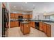 Modern kitchen with wood cabinets, island, and black appliances at 19661 N Echo Rim Dr, Surprise, AZ 85387