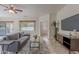 Cozy living room features grey sofa, coffee table, TV console, and large window at 19661 N Echo Rim Dr, Surprise, AZ 85387