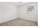 A bright bedroom with neutral carpet, white walls, and a window at 4244 E Bradford Ave, San Tan Valley, AZ 85140