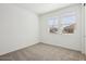 A carpeted bedroom with white walls and two windows at 4244 E Bradford Ave, San Tan Valley, AZ 85140