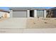 Single-story home showcasing gray stucco and drought-resistant landscaping with a two car garage and covered entry at 4244 E Bradford Ave, San Tan Valley, AZ 85140