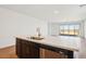 Kitchen island with quartz countertop, stainless steel sink, and dark cabinets at 4244 E Bradford Ave, San Tan Valley, AZ 85140